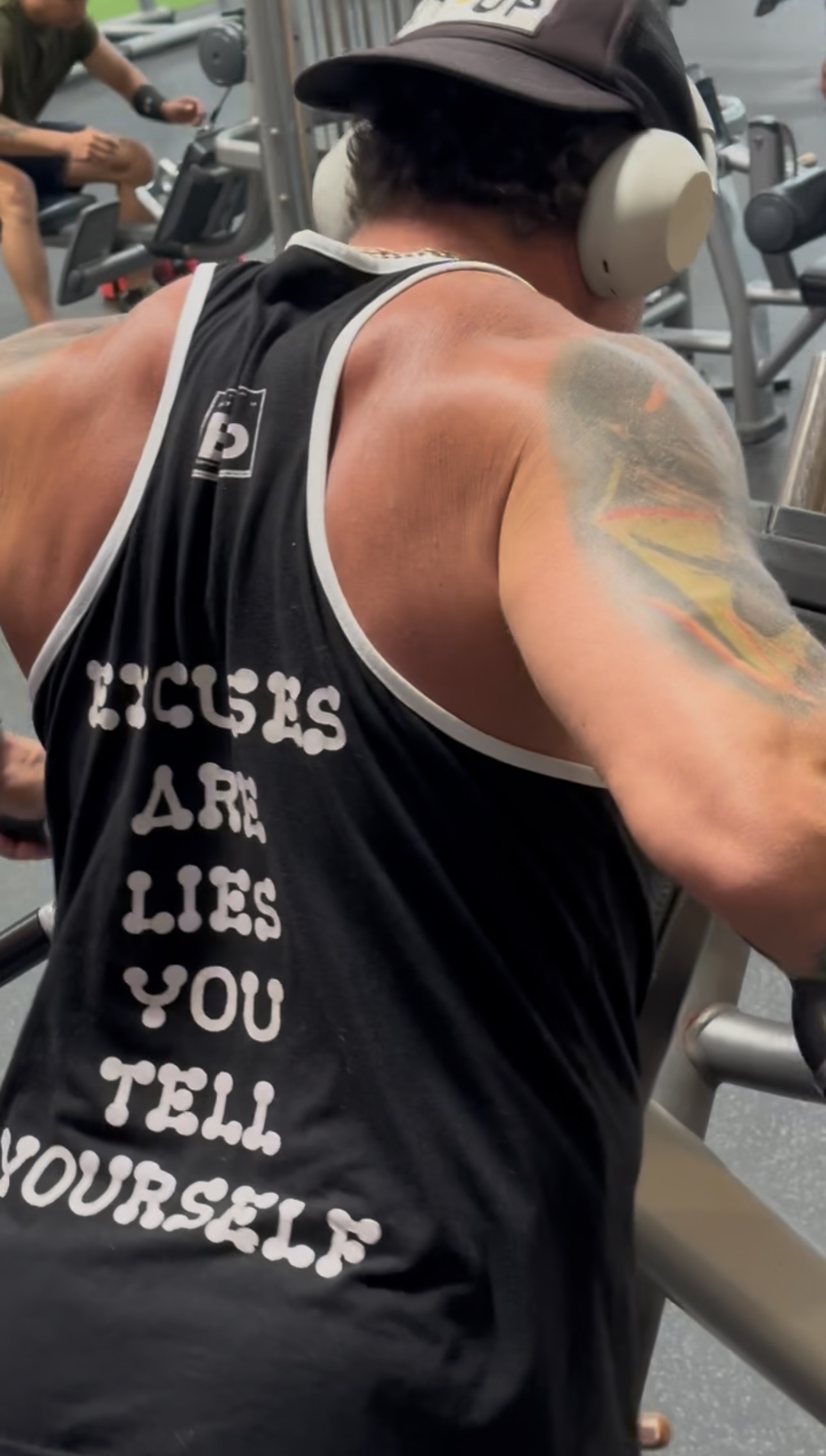 Black and white photograph of a gym tank reading Excuses Are Lies You Tell Yourself