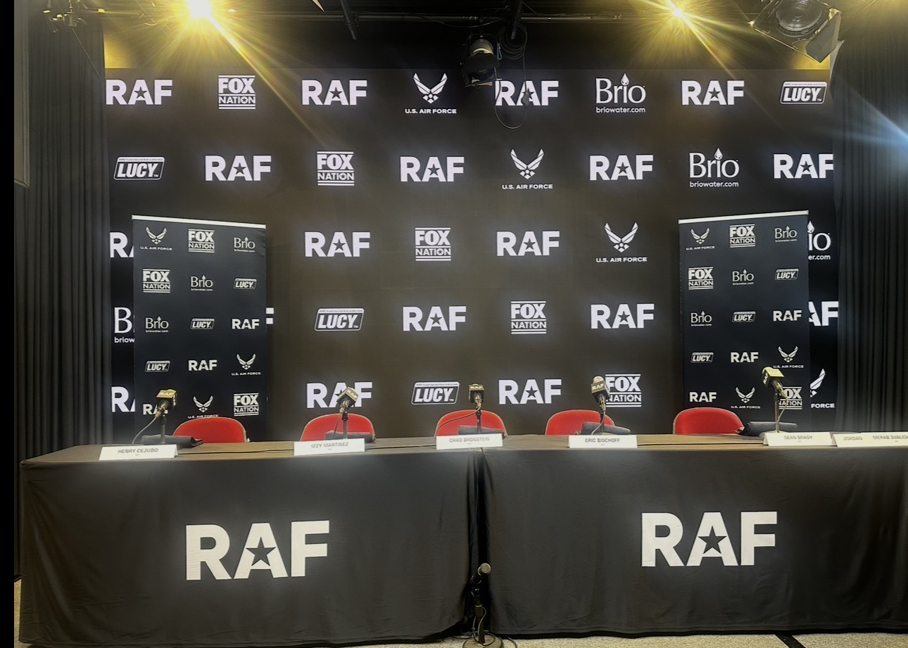 Black and white photograph of an RAF press conference table and media backdrop