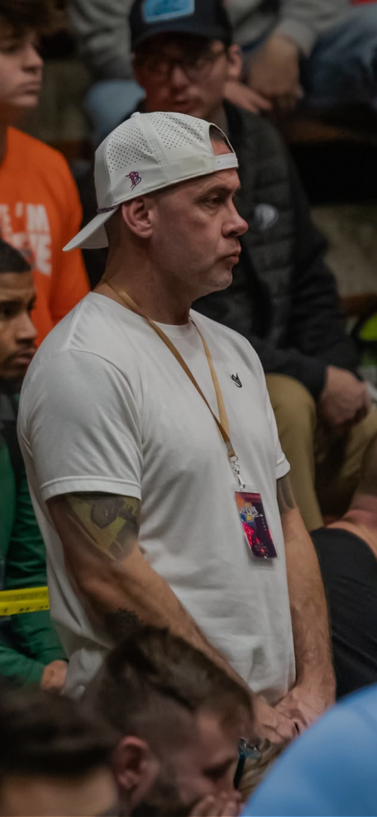 Black and white candid portrait of Anton Payne standing in a wrestling arena crowd