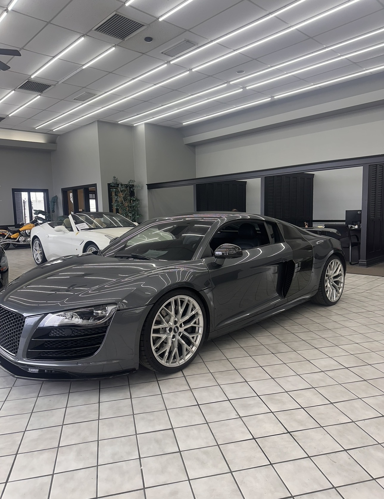 Black and white photograph of a sports car on a showroom floor